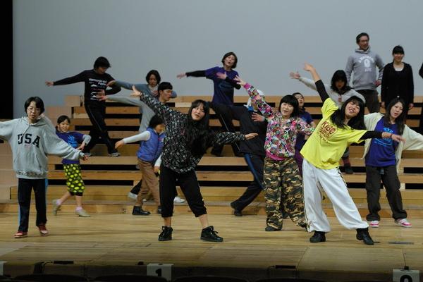 両手を広げ踊る子供達の写真